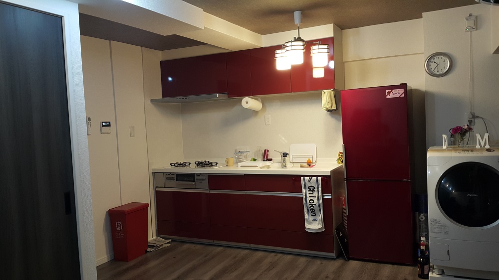 LDKは、壁紙や建具に黒を取り入れたモダンな空間。鮮やかな赤のキッチンが差し色になっている。