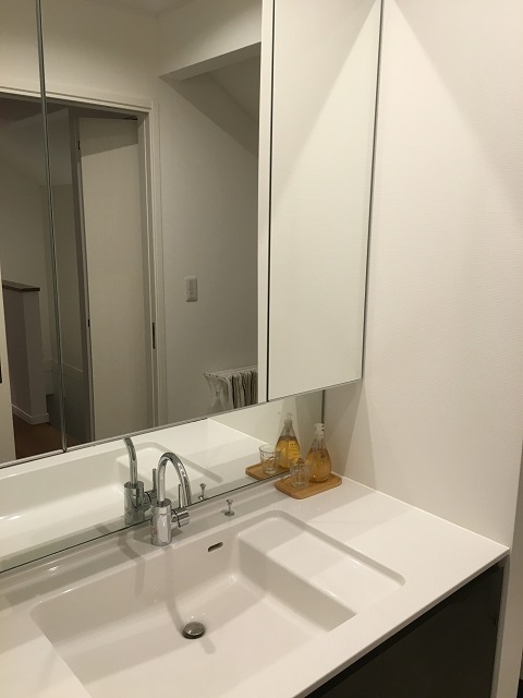 ワイドタイプの洗面台は、3面鏡付きで使いやすいそう。「浴室同様、メンテナンスは大変ですが、使うたびに拭くように心がけています」