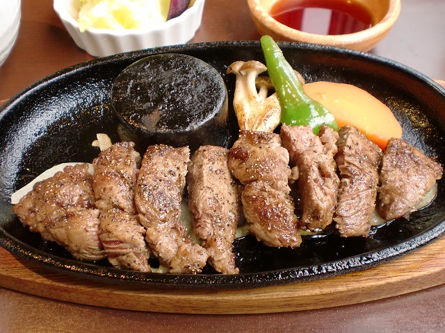 ヌーベル クアトロの名物「メガネ肉のステーキ」はボリューム満点！　熱々の鉄板で焼き加減を調整しながら食べられる。